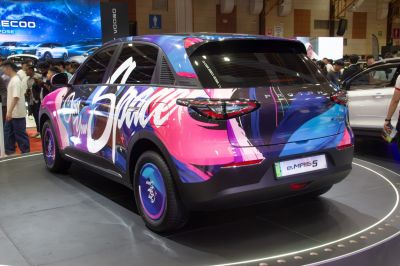 Rear view of electric SUV with vibrant graffiti-style multi-color wrap.