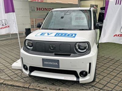 Front view of a compact electric vehicle with round headlights and EV badge