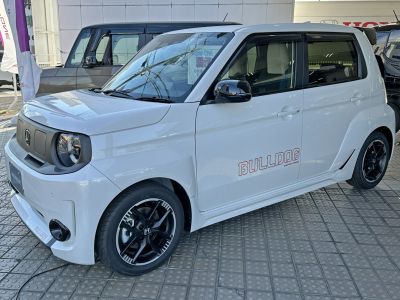 Electric compact with round headlights and custom black rims