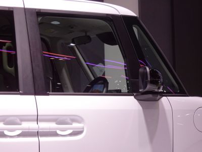 Close-up of car side door handle and mirror with window reflection