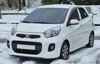 Front view of compact white hatchback with modern headlights and grille