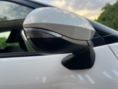 Side mirror with integrated indicator on white car door