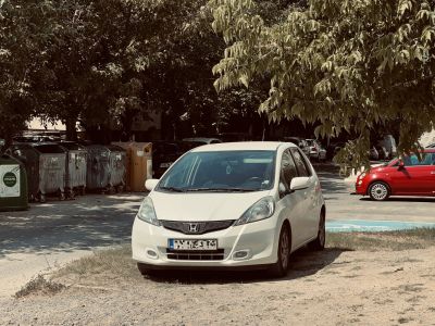 Front view of compact white hatchback with sporty grille and fog lights