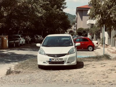 Front view of white compact hatchback with fog lights