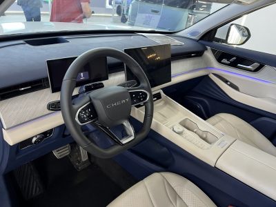 Dual digital screens, modern steering wheel, and luxury ambient lighting.
