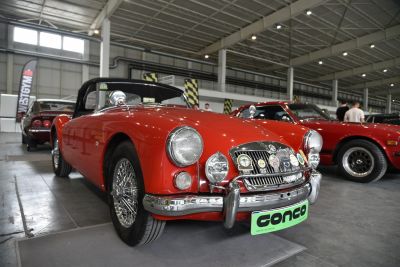 Bright red convertible with chrome wire wheels and twin chrome headlights