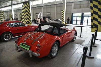 Red vintage convertible with black soft top and chrome rear luggage rack