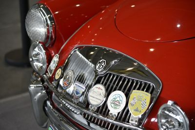 Close-up of vintage front grille with multiple badges and headlights