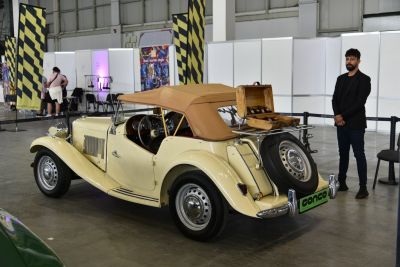 Vintage convertible with tan soft top and rear trunk rack