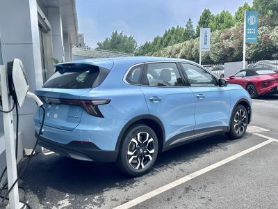 Electric SUV charging at station, rear and side view
