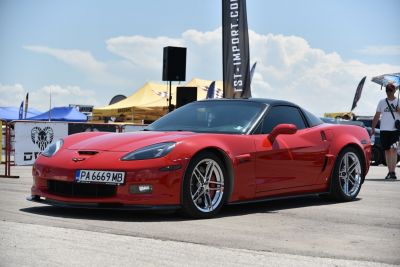 Front-side view of a red sports coupe with chrome wheels
