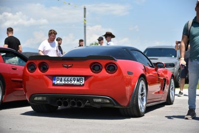 Rear view of a red sports coupe with quad exhausts and round taillights.