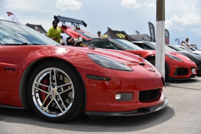Close-up of red sports car front with chrome alloy wheel and headlight