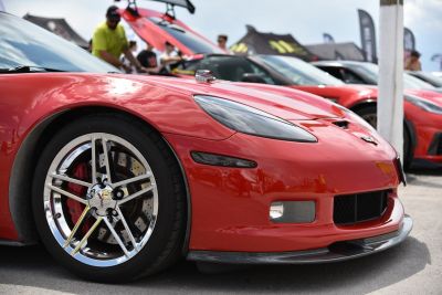 Front wheel and headlight detail of a red sports coupe