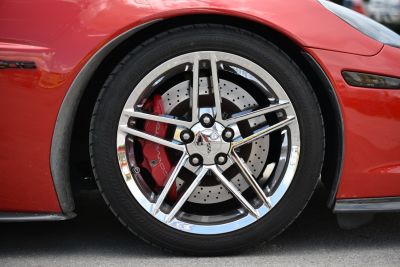 Close-up of alloy wheel with red brake caliper and drilled disc brake