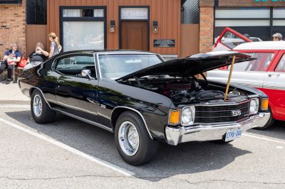 Classic muscle car with open hood and visible engine