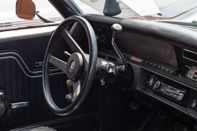 Classic steering wheel and dashboard with manual gearshift in vintage 1970s car