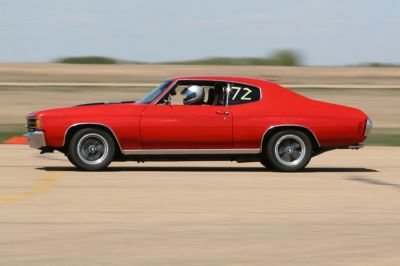 Red classic muscle car with sport coupe profile in motion