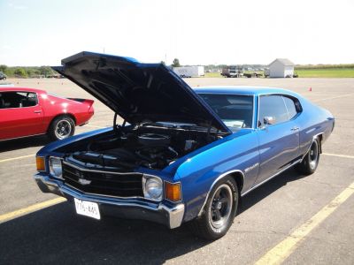 Open hood blue muscle car with classic grille and sleek coupe design