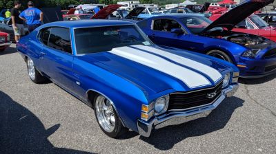 Blue muscle car with white dual racing stripes and chrome grille.