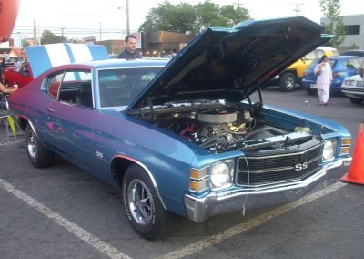 Front angle view of a muscle car with open hood and visible engine bay