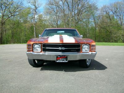 Front view of muscle car with racing stripes and chrome bumper