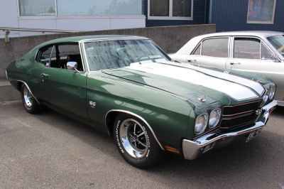 Green muscle coupe with white racing stripes and chrome bumpers