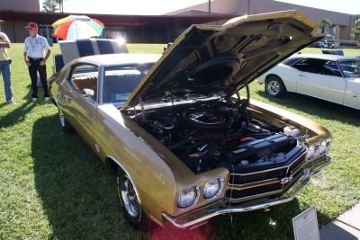 Open engine bay and front grille with dual headlights on a 1970 muscle car.