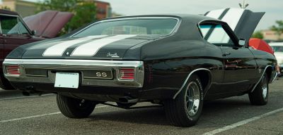 Rear view of a muscle car with dual racing stripes and SS badge