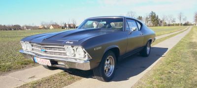 Classic muscle car front with quad headlights and raised hood