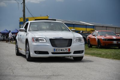 Front view of white sedan with LED headlights and chrome grille