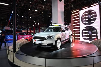 SUV with rugged fender flares and rooftop gear displayed on rotating platform.