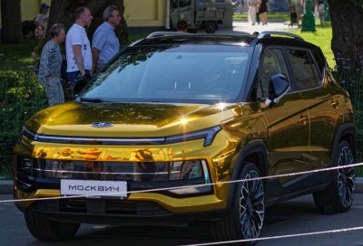 Modern electrified SUV with gold reflective body and black roof.