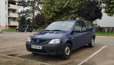 Blue compact pick-up truck with black bumpers and steel wheels parked outdoors.