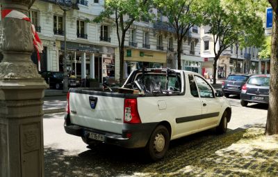 Rear view of a white pick-up truck with cargo bed on city street
