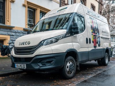 Front and side view of a facelifted panel van with beverage advertising.