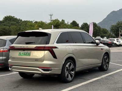 Rear-side view of a beige large SUV with LED taillights and tinted windows