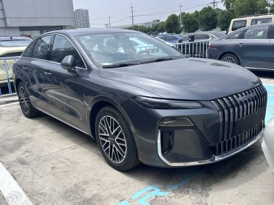 Front and side view of sedan with large vertical grille and unique alloy wheels
