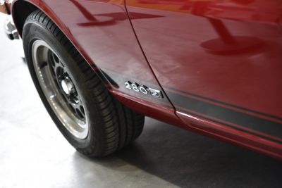 Close-up of side emblem and wheel on red vintage sports car