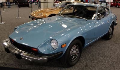 Blue vintage sports coupe front-side with round headlights, chrome bumper