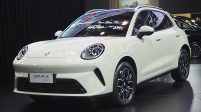 Front-side view with round LED headlights and multi-spoke alloy wheels