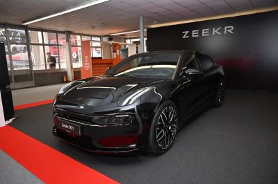 Front three-quarter view of a sleek black modern electric sedan with LED headlights and alloy wheels.