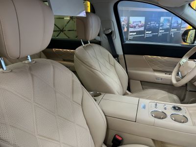 Beige perforated leather seats with diamond stitching and center console controls.