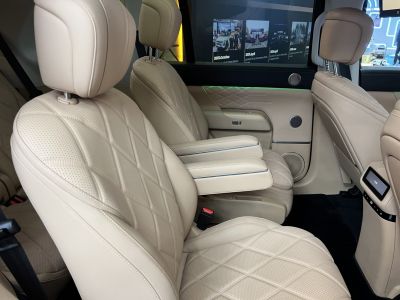 Beige leather car seats with diamond stitching and dual armrests