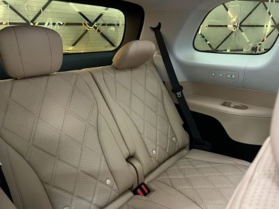 Beige quilted leather rear passenger seats with seat belts and control buttons