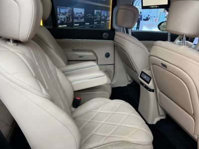 Beige leather rear seating with foldable armrest and quilted pattern