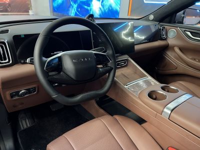 Modern steering wheel and dual digital displays in brown leather interior