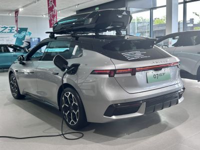 Electric SUV charging cable connected, roof cargo box mounted