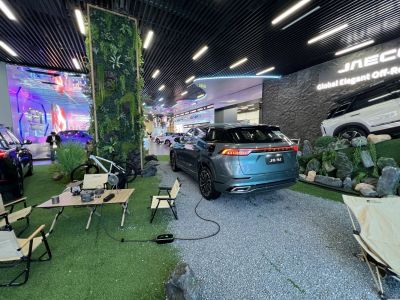 Rear view of electric SUV with charging cable in exhibition