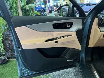 Beige leather door panel with control buttons and speaker grill